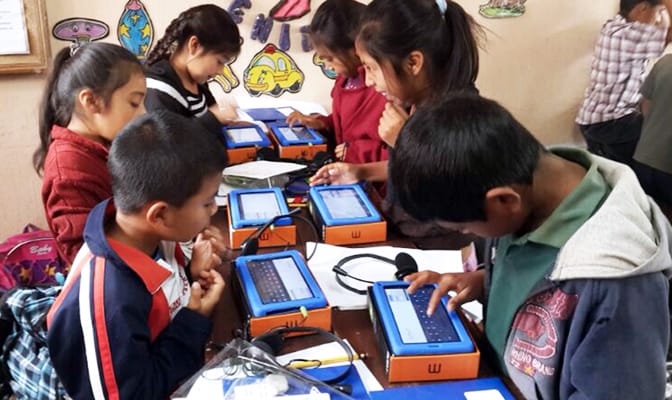 Young boys and girls access offline learning materials on tablets provided by Google and Learning Equality.