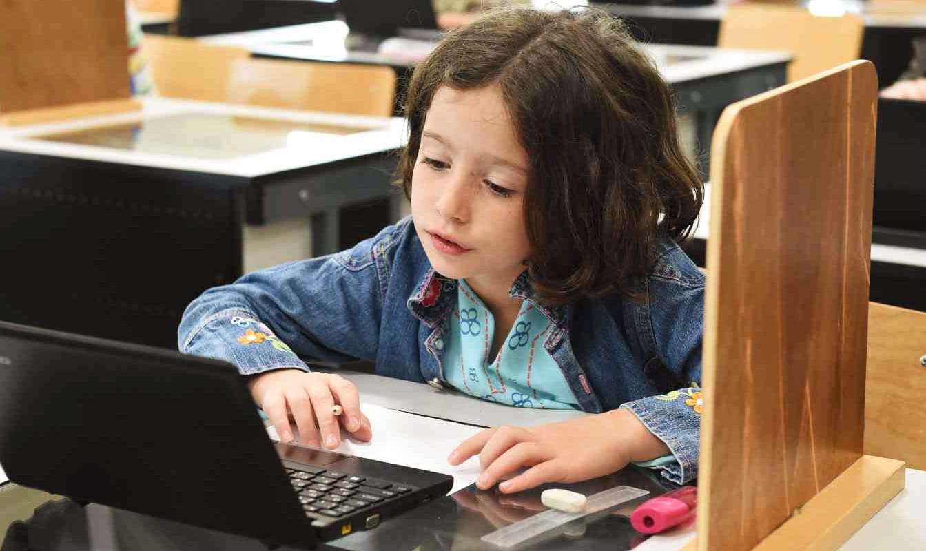A young student works on a laptop provided by the Clooney Foundation for Justice.