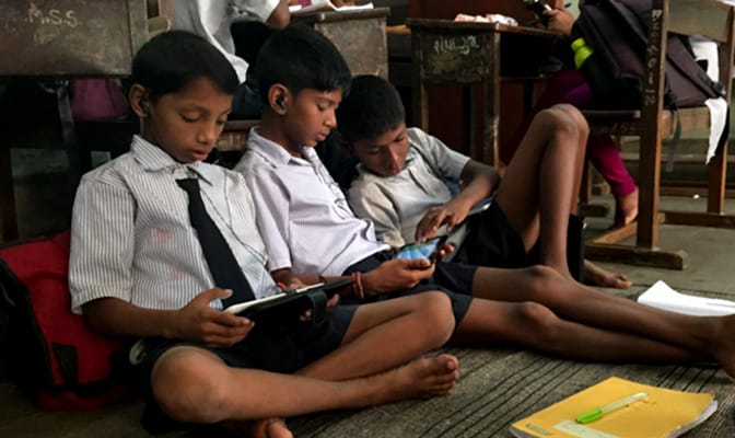 Students using tablets to access learning materials.