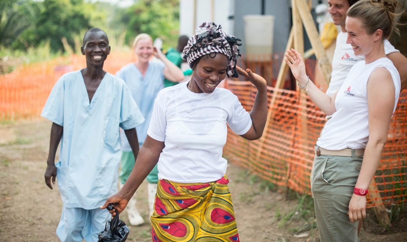 MSF volunteers laugh while sharing a joyful moment with an at-risk local.