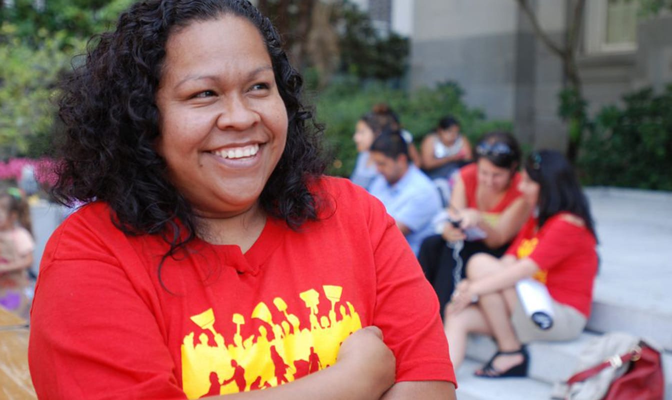 An NDWA-affliated domestic worker smiles while looking at a colleague