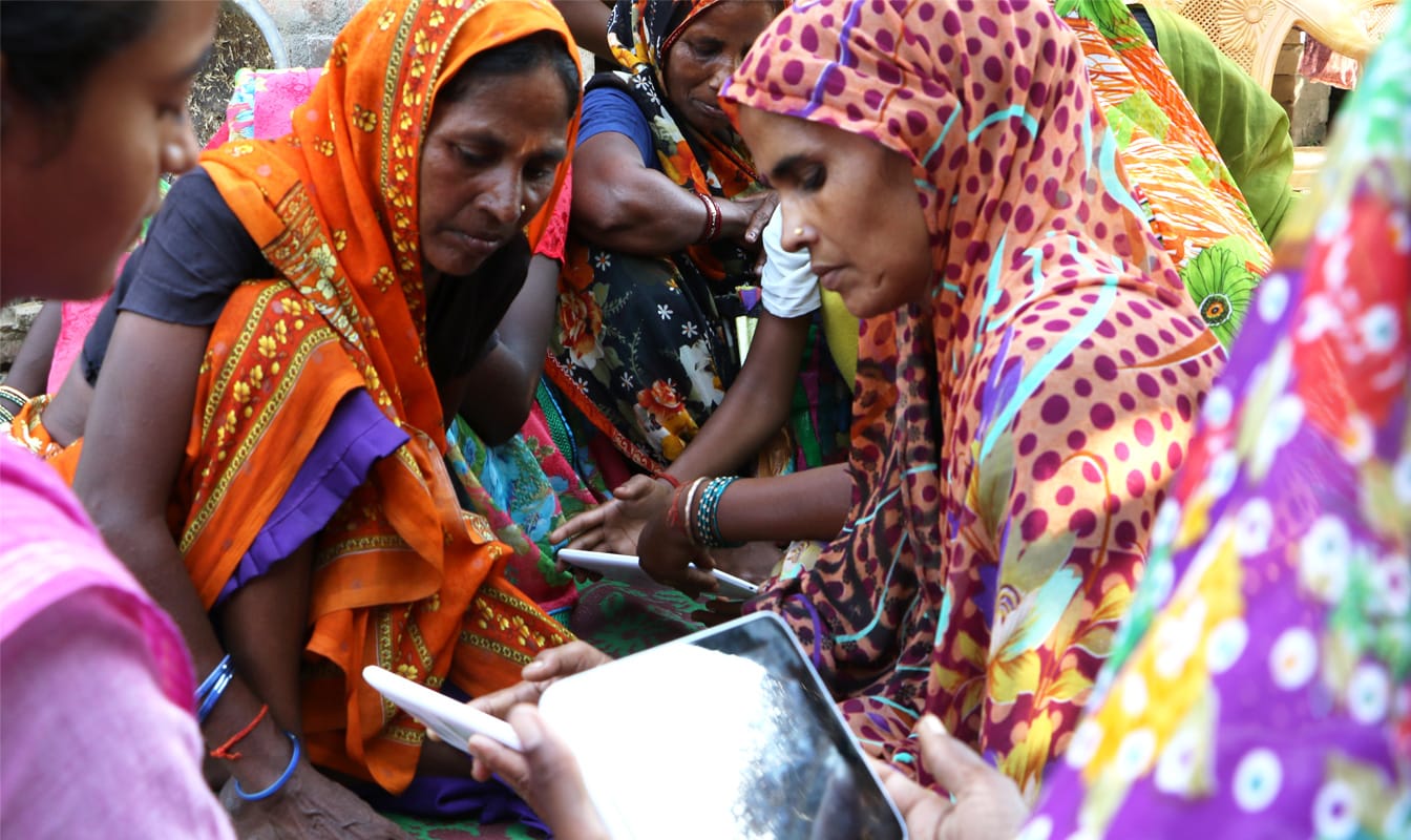 A group of Indian women use tablets supplied by Google and the Pratham Foundation.